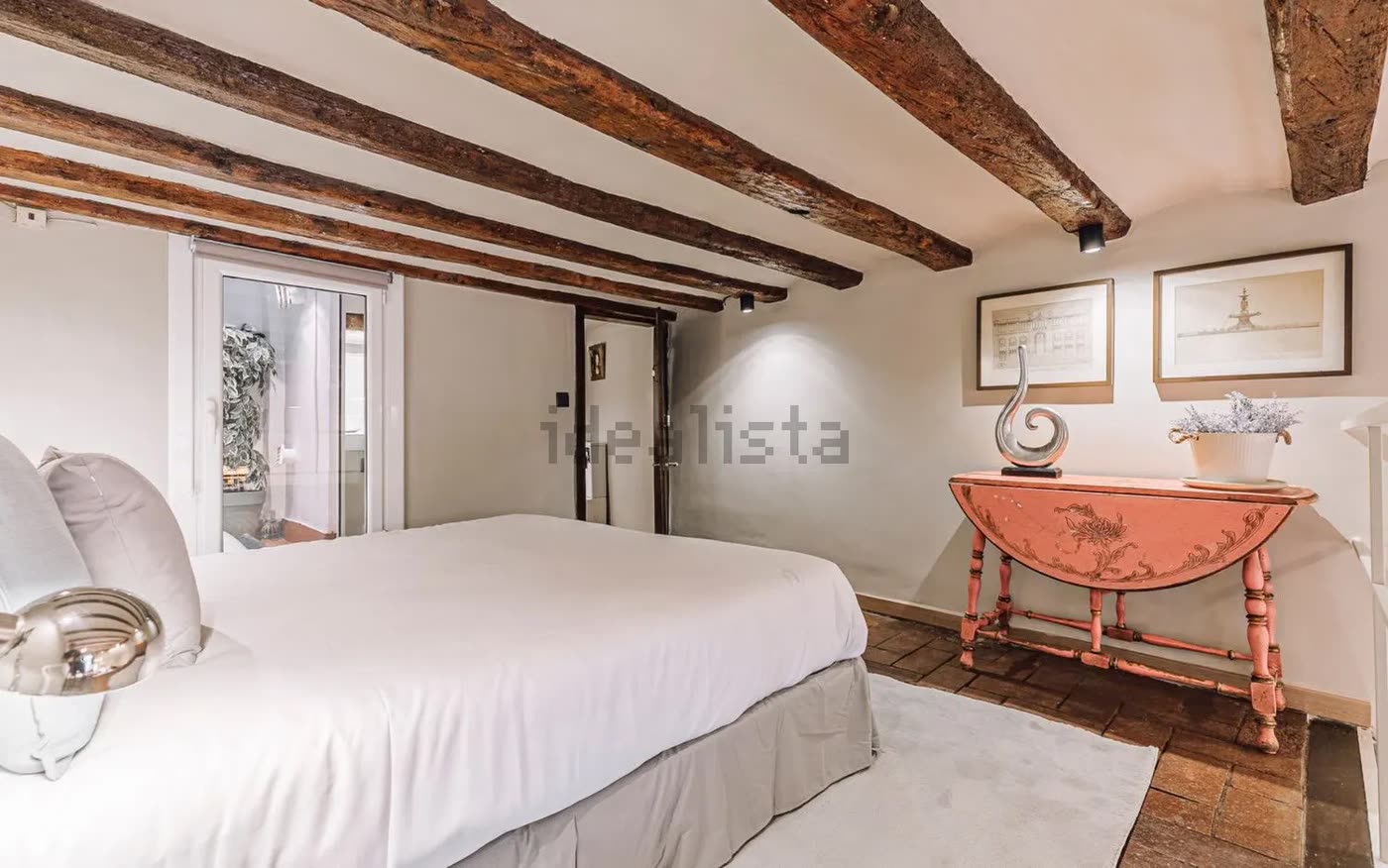 Dormitorio desde otro ángulo, con consola rosa y acceso al patio