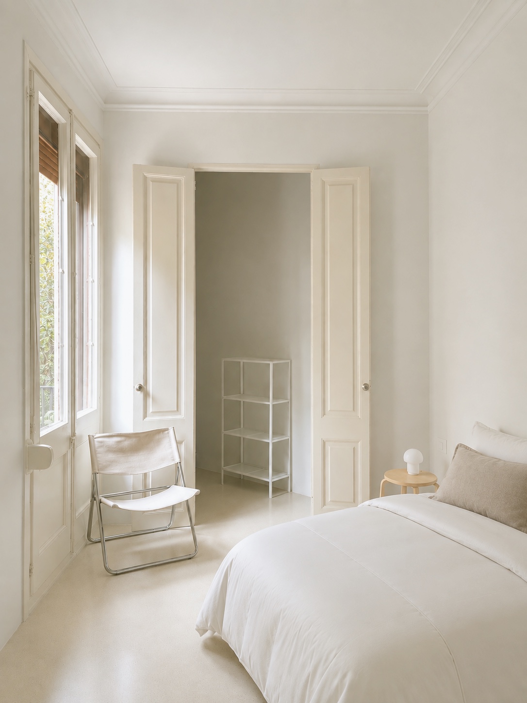 Habitación principal con la cama vestida en blanco y las ventanas a la calle