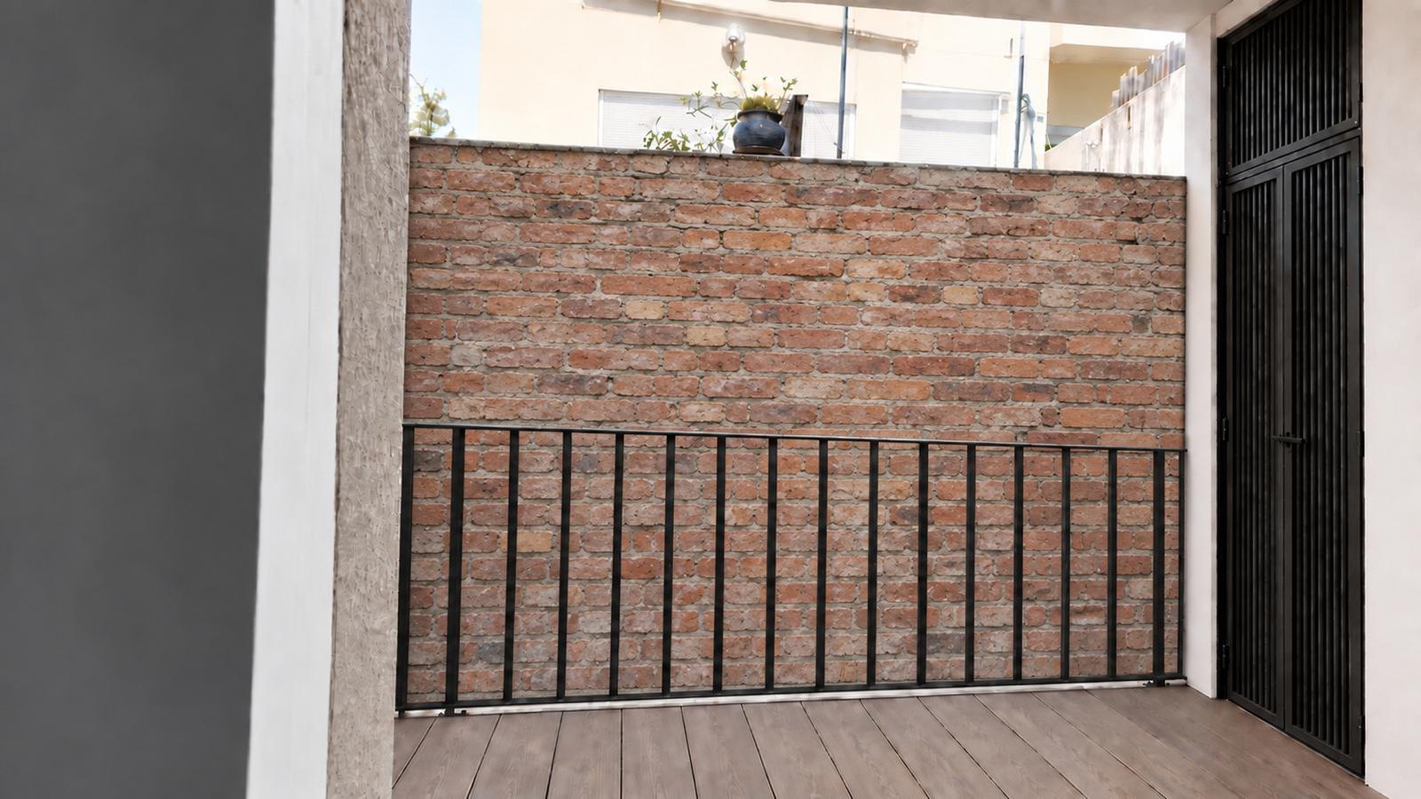 Imagen virtual del balcón posterior de 5 m² con barandilla de forja y muro de ladrillo visto